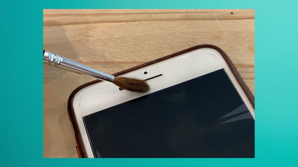 clean microphone on iPhone by using a toothbrush or paintbrush